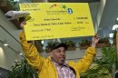 Quezada holds up the promotional Powerball jackpot check of $338 million at the New Jersey Lottery headquarters in Trenton