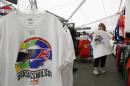 Rita Panike, of Redding, Calif., looks over t-shirts paying tribute to Justin Wilson before practice for the IndyCar auto race Friday, Aug. 28, 2015, in Sonoma, Calif. IndyCar is headed into a somber championship weekend as the paddock mourns the death of popular driver Justin Wilson instead of celebrating its season finale. Wilson, of Great Britain, died Aug. 24 from injuries sustained at Pocono Raceway. (AP Photo/Eric Risberg)