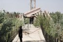 A fighter from Syrian rebel group Jabhat al-Nusra stands on historical Deir al-Zor Suspension Bridge damaged by what activists said was by forces loyal to Syria's President Bashar al-Assad