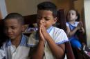 Children pray at the Father Usera daycare center in Havana
