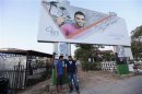 Youths stand in front of an electoral banner in Benghazi
