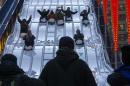 People watch as fans ride the luge slide during Super Bowl Boulevard activities ahead of Super Bowl XLVIII in New York