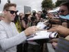 Formula One Red Bull driver and world champion Sebastian Vettel of Germany signs autographs after he arrived at Albert Park track for the Australian Grand Prix in Melbourne, Australia, Thursday, March 14, 2013. The season-opening race is scheduled for this weekend. (AP Photo/Rob Griffith)