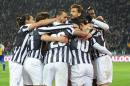 Juventus players hug their teammate Carlos Tevez, hidden at center, after he scored during a Serie A soccer match between Juventus and Parma at the Juventus stadium, in Turin, Italy, Wednesday, March 26, 2014. (AP Photo/Massimo Pinca)