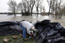 Bob Bailey tinkers with a pump as he tries to keep floodwater from the Mississippi River out of one of his rental properties Sunday, April 21, 2013, in Clarksville, Mo. Many have come to the aid of the tiny community, working since Wednesday to build a makeshift sandbag levee that seemed to be holding as the crest, expected to be 11 feet above flood stage, approaches. (AP Photo/Jeff Roberson)