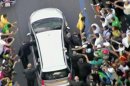 In this image from video, a crowd mobs the silver Fiat carrying Pope Francis through Rio de Janeiro on Monday, July 22, 2013. Ecstatic believers forced the closed Fiat to stop several times as they swarmed around during the drive from the airport to an official opening ceremony in the center of the city. (AP Photo)