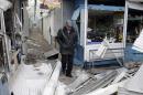 A man walks past a shop which was recently damaged by shelling, at a local market in Donetsk
