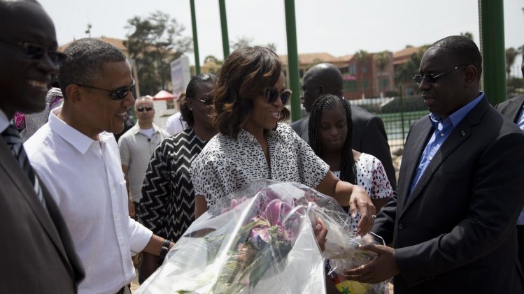 President Barack Obama and first lady Michelle Obama receive flowers after arriving for a tour of Goree Island, Thursday, June 27, 2013, in Goree Island, Senegal. Goree Island is the site of the former slave house and embarkation point built by the Dutch in 1776, from which slaves were brought to the Americas. (AP Photo/Evan Vucci)