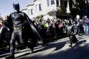 Miles Scott, dressed as Batkid, right, runs with Batman after saving a damsel in distress in San Francisco, Friday, Nov. 15, 2013. San Francisco turned into Gotham City on Friday, as city officials helped fulfill Scott's wish to be "Batkid." Scott, a leukemia patient from Tulelake in far Northern California, was called into service on Friday morning by San Francisco Police Chief Greg Suhr to help fight crime, The Greater Bay Area Make-A-Wish Foundation says. (AP Photo/Jeff Chiu)