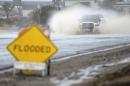 An SUV drives through a flooded section of a street in Hesperia, Calif., Tuesday, Jan. 5, 2016. El Nino storms lined up in the Pacific, promising to drench parts of the West for more than two weeks and increasing fears of mudslides and flash floods in regions stripped bare by wildfires. (David Pardo/The Victor Valley Daily Press via AP) MANDATORY CREDIT