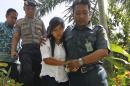 Philippine national Mary Jane Fiesta Veloso, center, is escorted by a court official and a police officer upon arrival for a judicial review hearing at Sleman District Court in Yogyakarta, Indonesia, Tuesday, March 3, 2015. Indonesia is nearly ready to execute by firing squad nine foreigners and an Indonesian condemned for drug smuggling as diplomatic squabbles persist over the executions. The preparations at the execution site have been completed and four foreign convicts, including 30-year-old Veloso, will be transferred to Nusakambangan Island's maximum-security prison facilities this week, said Attorney General Muhammad Prasetyo. (AP Photo)