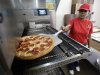 FILE - In this Thursday, May 24, 2012, file photo, employee Rosy Tirado pulls a pepperoni pizza from an oven at a Pizza Patron Dallas, Texas. While lower-wage American workers have accounted for the lion's share of the jobs created since the 2007-2009 Great Recession, a survey released March 2013 shows that they are also among the most pessimistic about their future career prospects, their job security and their finances. (AP Photo/Tony Gutierrez)