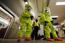Emergency personnel stand in front of a subway train before a re-enactment of a hazardous situation in Toronto