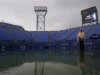 A man walks courtside during a downpour at the U.S. Open tennis tournament in New York