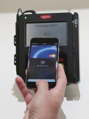 Apple Pay is demonstrated at Apple headquarters on Thursday, Oct. 16, 2014 in Cupertino, Calif. In announcing a Monday launch date, Apple CEO Tim Cook said deals have been made with hundreds of additional banks since the service was announced last month. Cook also said additional merchants plan to accept Apple Pay by the end of the year. (AP Photo/Marcio Jose Sanchez)