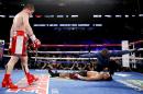 Canelo Alvarez, left, watches after knocking down Amir Khan during their WBC middleweight title fight Saturday, May 7, 2016, in Las Vegas. (AP Photo/John Locher)
