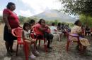 Residents listen to the authorities and Red Cross on the volcano's activity and evacuation, near the area of the Chaparrastique volcano in the municipality of Placitas outside San Salvador