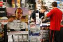 Game enthusiasts purchase the latest release of "Grand Theft Auto Five" after the game went on sale at the Game Stop store in Encinitas, California