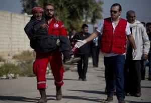 A man is helped by a Red Crescent worker on his way …