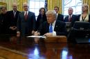 Trump signs a memorandum to security services directing them to defeat the Islamic State in the Oval Office at the White House in Washington