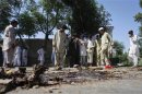 Residents gather at the site of a bomb attack in the outskirts of Peshawar