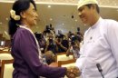 Myanmar opposition leader Aung San Suu Kyi, left, shakes hands with Htay Oo, right, general secretary of Union Solidarity and Development party headed by President Thein Sein, as she attends a regular session of Myanmar Lower House in Naypyitaw, Myanmar, Wednesday, May 2, 2012. Suu Kyi was sworn in to Myanmar's military-backed parliament Wednesday, taking public office for the first time since launching her struggle against authoritarian rule nearly a quarter century ago. (AP Photo/Khin Maung Win)