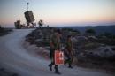 Israeli soldiers walk by an "Iron Dome" battery, a short-range missile defence system near Jerusalem on September 8, 2013