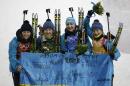 From left, Ukraine's relay team Vita Semerenko, Juliya Dzhyma, Olena Pidhrushna and Valj Semerenko pose with an Ukraine's flag, after winning the gold medal in the women's biathlon 4x6k relay at the 2014 Winter Olympics, Friday, Feb. 21, 2014, in Krasnaya Polyana, Russia. (AP Photo/Lee Jin-man)