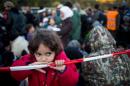 A girl plays as refugees wait at the Slovenian-Austrian border in Spielfeld on October 23, 2015