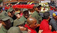 The coffin of deceased Venezuelan leader Hugo Chavez is driven through the streets of Caracas after leaving the military hospital where he died of cancer, in Caracas March 6, 2013. REUTERS/Carlos Garcia Rawlins