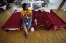 Rhonda Etienne of Davant,La., holds her niece Nevaeh Etienne, three months, in an evacuation shelter in Belle Chasse, La., in anticipation of Tropical Storm Karen, Saturday, Oct. 5, 2013. The East Bank of Plaquemines Parish has been under a mandatory evacuation, which has been downgraded to a voluntary evacuation. (AP Photo/Gerald Herbert)