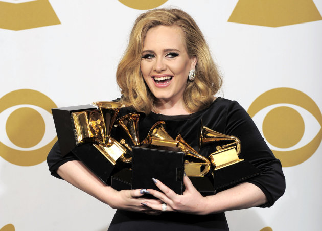 FILE - This is a Sunday, Feb. 12, 2012 file photo of Adele as she poses backstage with her six awards at the 54th annual Grammy Awards on Sunday, Feb. 12, 2012 in Los Angeles. Adele won awards for best pop solo performance for "Someone Like You," song of the year, record of the year, and best short form music video for "Rolling in the Deep," and album of the year and best pop vocal album for "21." Adele is getting a new medal to go alongside her Grammys and Academy Award _ an honor from Queen Elizabeth II. The "Rumor Has It" and "Skyfall" singer was named a Member of the Order of the British Empire, or MBE on Friday June 14, 2013 in the queen's annual Birthday Honors list. (AP Photo/Mark J. Terrill, File)