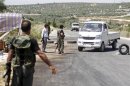 MeFree Syrian Army fighters man a checkpoint at the entrance of Salqin city, Idlib governorate