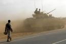 Saudi soldiers drive an army tank in the southern Jizan province, near the border on January 27, 2010