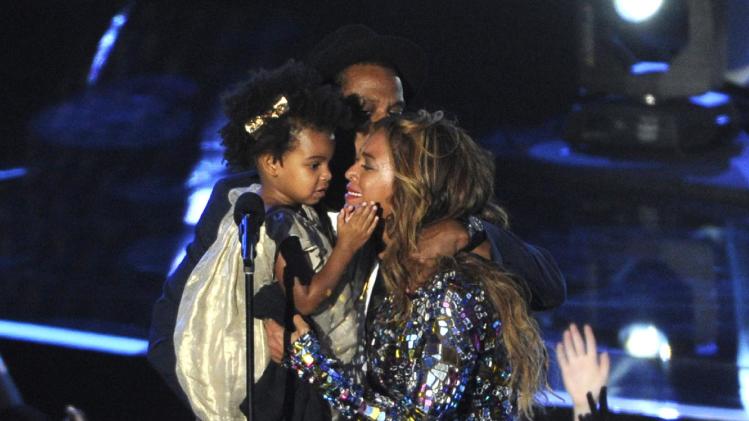 FILE - In this Sunday, Aug. 24, 2014 file photo, Beyonce on stage hugs Jay Z and their daughter Blue Ivy as she accepts the Video Vanguard Award at the MTV Video Music Awards at The Forum, in Inglewood, Calif. BET has suspended a producer after a joke about Blue Ivy’s hair aired Monday, Aug. 25, 2014, on the network’s music video countdown show, “106 & Park.” A source at the network, who spoke on the condition of anonymity because the person was not allowed to discuss the matter publicly, said the producer was suspended after the ill-fitting joke about Beyonce and Jay Z’s two-year-old daughter aired. (Photo by Chris Pizzello/Invision/AP, file)