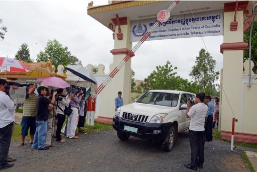 Journalists take pictures of a car at the gate of the Cambodia's war crimes court in Phnom Penh on September 16, 2012