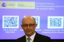 Spain's Treasury Minister Montoro stands in front of a screen showing a document representing the first draft of Spain's 2013 budget, during ceremony at Parliament