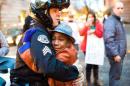 In this Tuesday, Nov. 25, 2014 photo provided by Johnny Nguyen, Portland police Sgt. Bret Barnum, left, and Devonte Hart, 12, hug at a rally in Portland, Ore., where people had gathered in support of the protests in Ferguson, Mo. (AP Photo/Johnny Huu Nguyen)