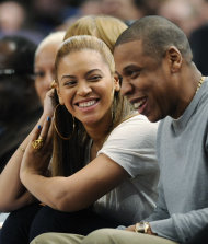 FILE - In this Feb. 20, 2012 file photo, entertainer Jay-Z reacts with his wife, Beyonce, during the third quarter of an NBA basketball game between the New York Knicks and New Jersey Nets, at Madison Square Garden in New York. Beyonce will battle her husband for video of the year at the BET Awards, and now both performers are confirmed to attend, The Associated Press reports Friday, June 29, 2012. Beyonce is the second most nominated act. She's up for six awards. Jay-Z is nominated for five. (AP Photo/Bill Kostroun, File)