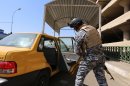 An Iraqi soldier searches a car at a checkpoint in Baghdad, on August 27, 2013