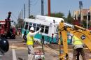 A valley metro bus sits mired in a collapsed, muddy street after a water main break flooded the area, Wednesday, Sept. 3, 2014 in Tempe, Ariz. Police say police officers and firefighters helped passengers get off the bus and that nobody was injured during the Wednesday morning incident though some businesses were flooded. (AP Photo/Matt York)