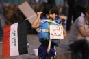 An Iraqi child wears a life jacket with a placard reading "I want to migrate" during a demonstration against corruption in Baghdad's Tahrir Square on September 11, 2015