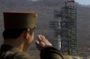 FILE - In this April 8, 2012, file photo, a North Korean soldier salutes in front of the country's Unha-3 rocket, slated for liftoff between April 12-16, at Sohae Satellite Station in Tongchang-ri, North Korea. North Korea may postpone the controversial launch of a long-range rocket that had been slated for liftoff as early as Monday, Dec. 10, 2012, North Korean state media said Sunday, Dec. 9, 2012. North Korea announced earlier this month that it would launch a three-stage rocket mounted with a satellite from its Sohae station southeast of Sinuiju sometime between Dec. 10 and Dec. 22. (AP Photo/David Guttenfelder, File)