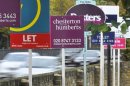 Cars pass property sales and letting signs in west London