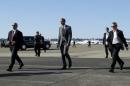 Secret Service agents flank Obama as he crosses the tarmac to greet people who watched him arrive aboard Air Force One at the Oregon Air National Guard Base in Portland, Oregon