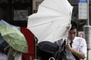 A man walks with his umbrella against strong winds as Typhoon Saola approaches Taiwan in Taipei