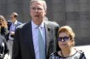 In this June 11, 2015, photo, former Florida Gov. Jeb Bush with wife Columba stand in front of the Wall of Memory at the Warsaw Uprising 1944 museum in Warsaw, Poland. Bush strolled the halls of the Polish parliament. He praised Germany's economic boom since the fall of the Berlin Wall. And he visited Estonia, a once-bleak Soviet state that now has a growing, free-market economy. If he was trying to stoke memories of his father and his legacy as president, Bush appears to have largely succeeded. (AP Photo/Alik Keplicz)