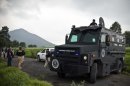 Mexican police officers block a road leading to a newly discovered mass grave in Tlalmanalco on August 22, 2013