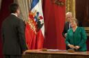 Chilean President Michelle Bachelet stands next to her Minister of Interior, Jorge Burgos (R) and Minister of Defense, Jose Antonio Gomez (L) during the presentation of the new Cabinet at La Moneda presidential palace on May 11, 2015