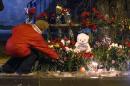 A women puts a flower outside a wreckage of a trolleybus in Volgograd, Russia, Tuesday, Dec. 31, 2013. Russian authorities ordered police to beef up security at train stations and other facilities across the country after a suicide bomber killed 14 people on a bus Monday in the southern city of Volgograd. It was the second deadly attack in two days on the city that lies just 400 miles (650 kilometers) from the site of the 2014 Winter Olympics. (AP Photo/Denis Tyrin)